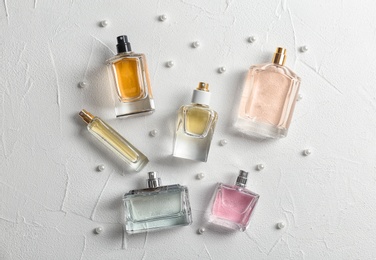 Photo of Beautiful composition with bottles of perfume on white background, flat lay