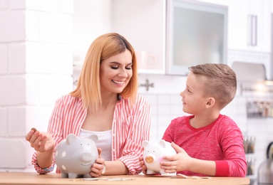 Family with piggy banks and money at home