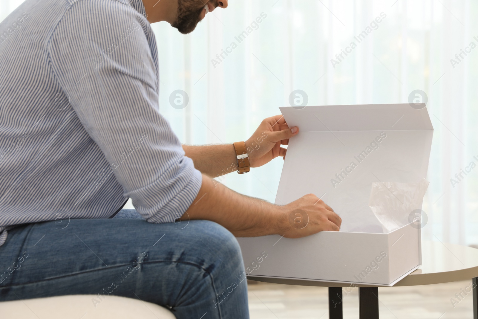 Photo of Man unpacking parcel at home, closeup. Online shopping