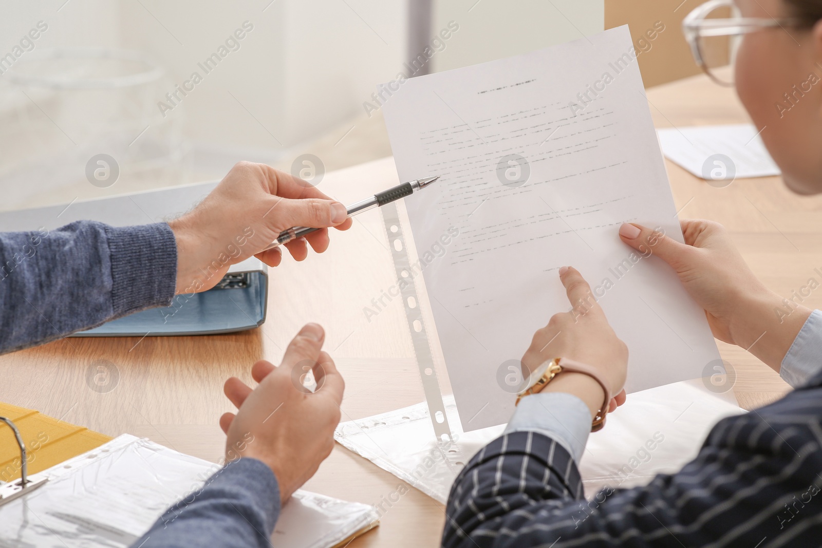 Photo of Businesspeople working with documents at wooden table in office, closeup