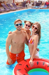 Photo of Happy family in pool on sunny day