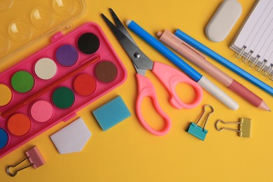Photo of Flat lay composition with notebook and other school stationery on orange background. Back to school