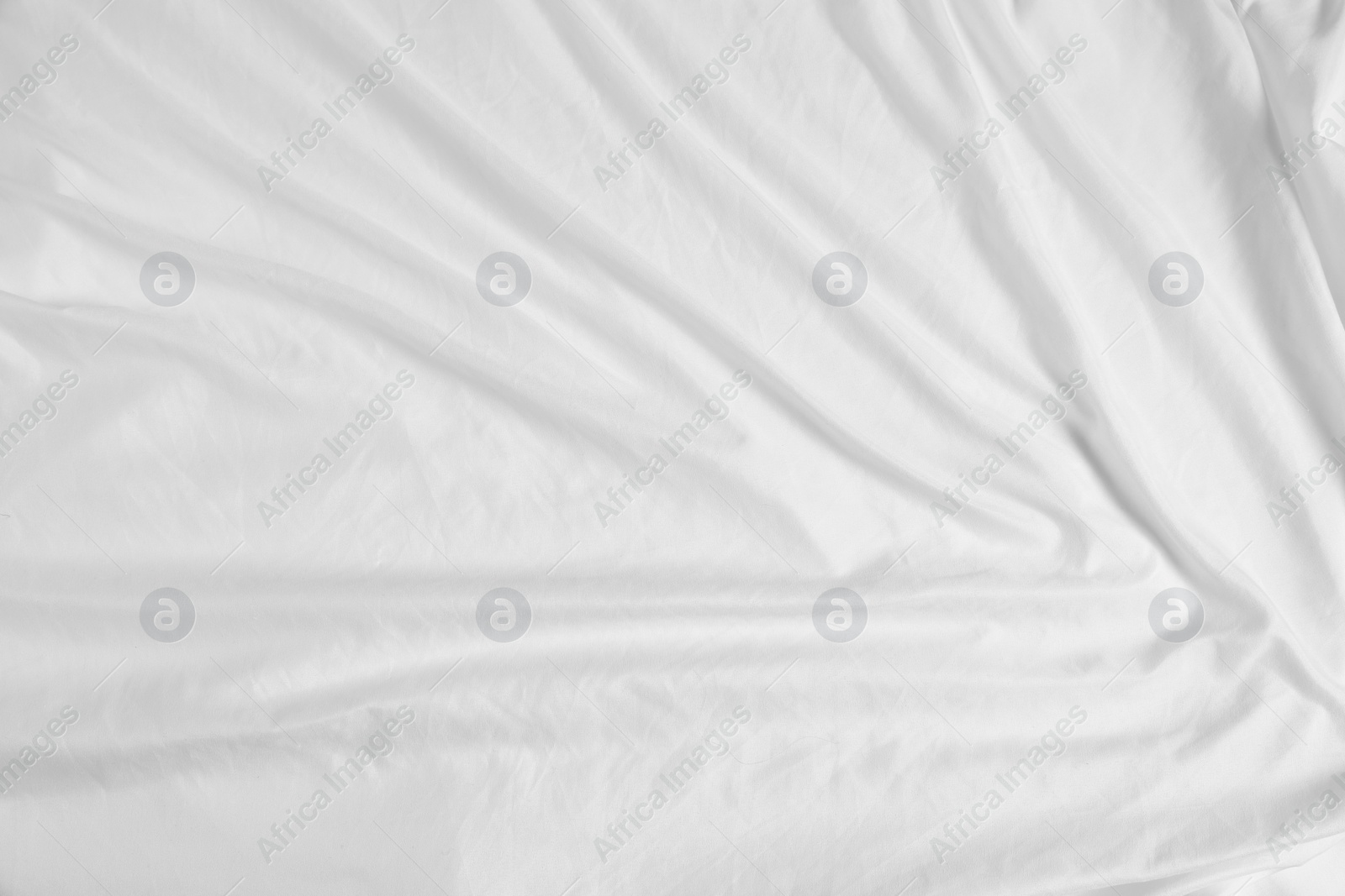 Photo of Crumpled white fabric as background, top view