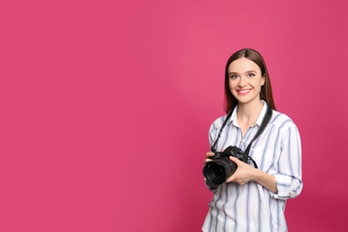 Photo of Professional photographer with modern camera on pink background. Space for text