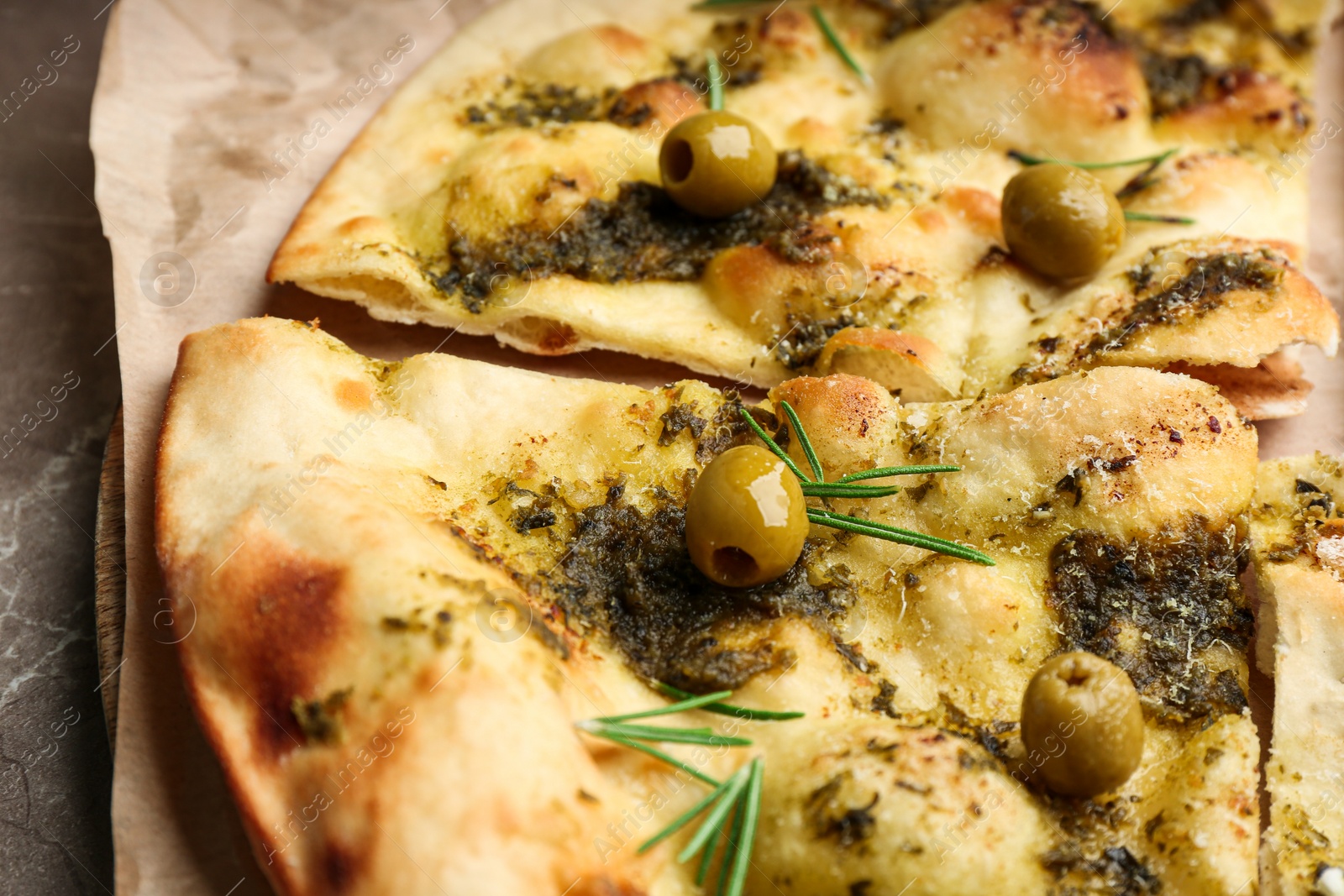 Photo of Delicious focaccia bread with green olives, closeup