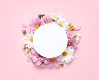 Photo of Flat lay composition with beautiful chamomile flowers and blank card on pink background. Space for text