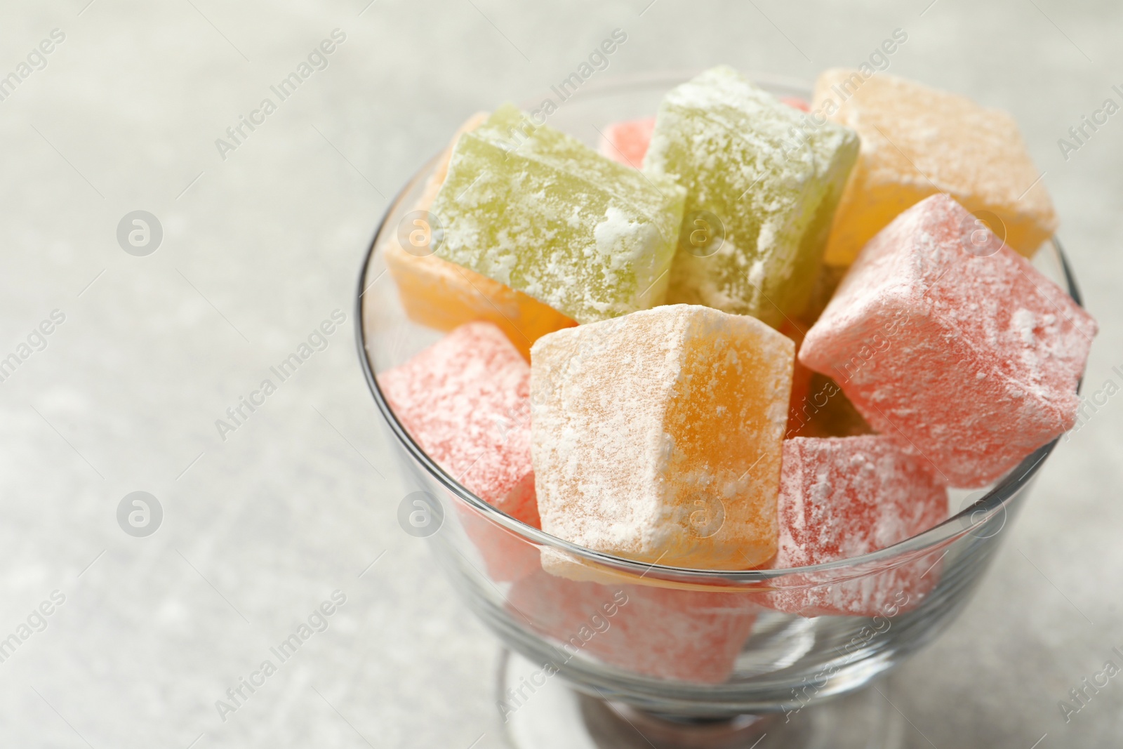 Photo of Turkish delight in dessert bowl on light table, closeup