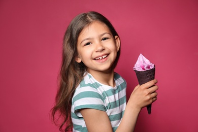 Photo of Adorable little girl with delicious ice cream against color background