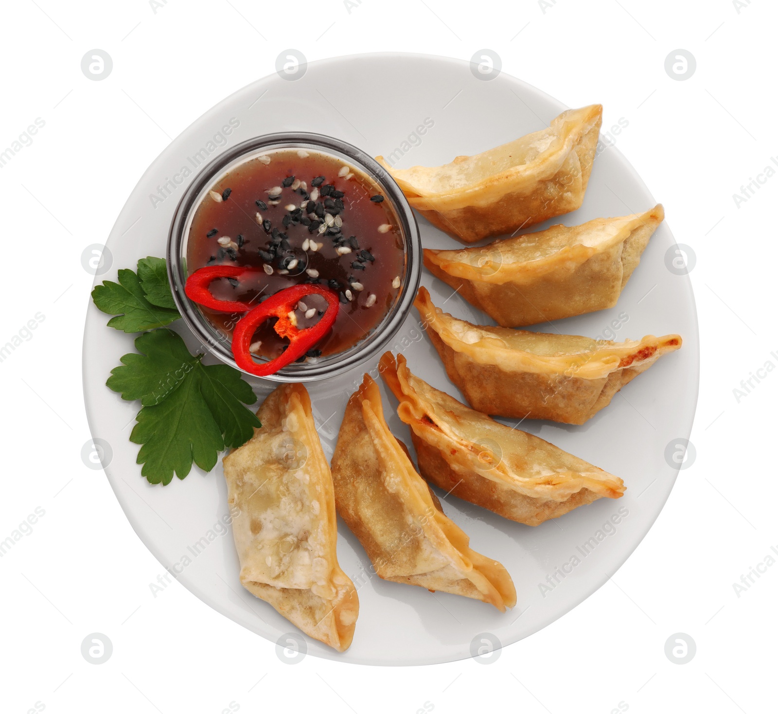 Photo of Delicious gyoza (asian dumplings) with soy sauce, pepper, parsley and sesame isolated on white, top view