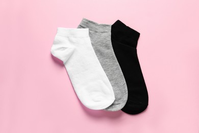 Different socks on pink background, flat lay