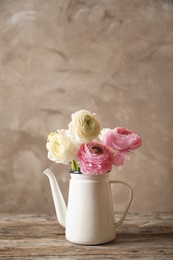 Photo of Vase with beautiful ranunculus flowers on wooden table