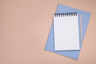 Blank notebook, planner and pencil on beige background, top view. Space for text