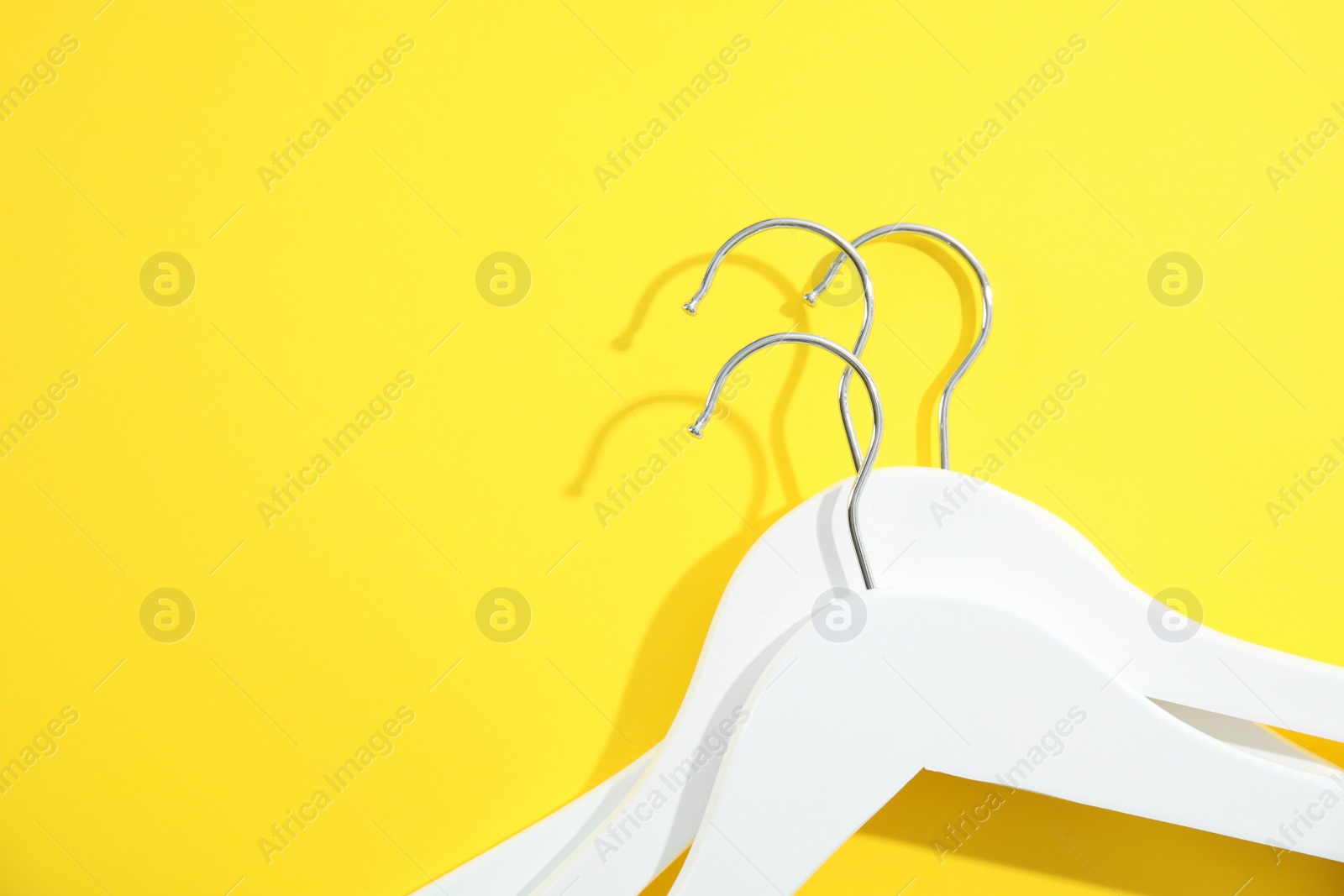 Photo of Flat lay composition with empty hangers on color background. Space for text