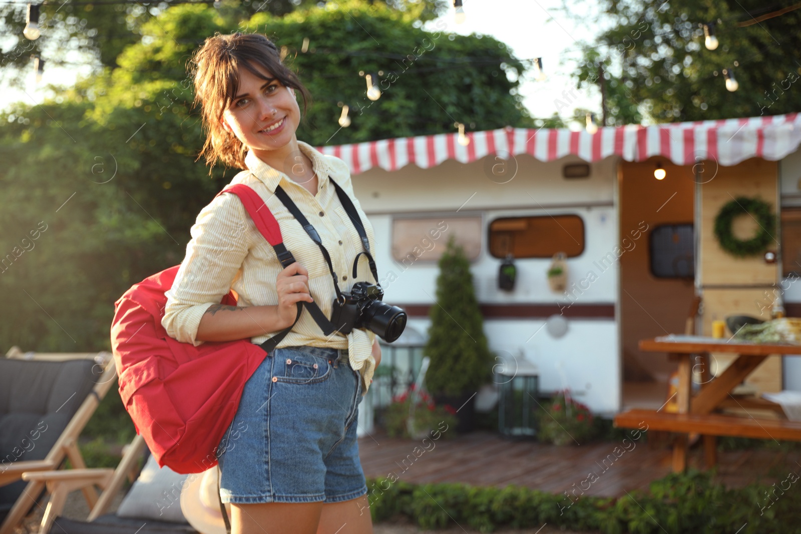 Photo of Young traveler with backpack and camera outdoors. Summer trip