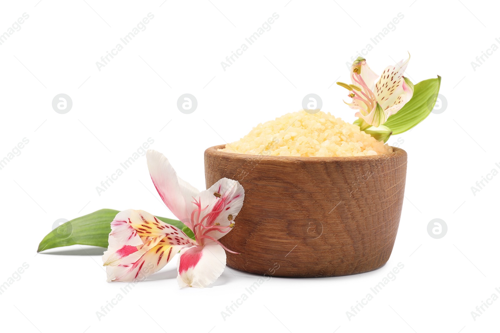 Photo of Orange sea salt in bowl, flowers and green leaves isolated on white