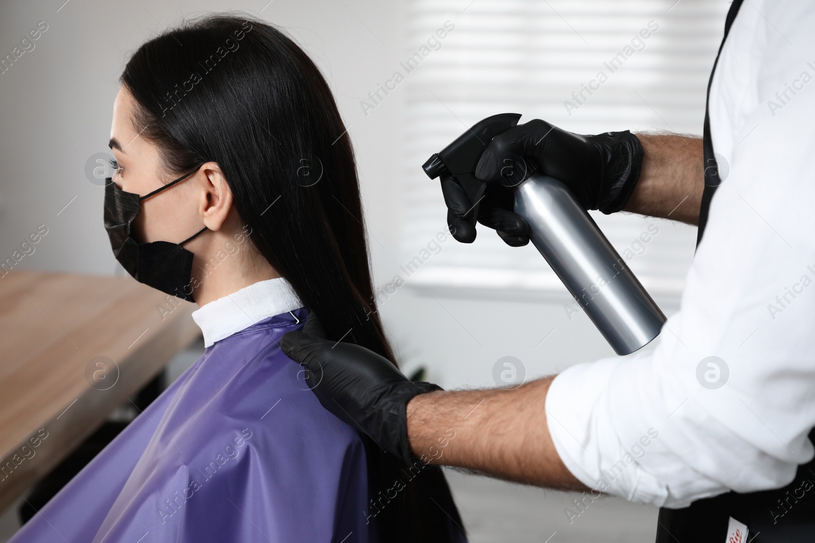 Photo of Professional stylist working with client in salon. Hairdressing services during Coronavirus quarantine