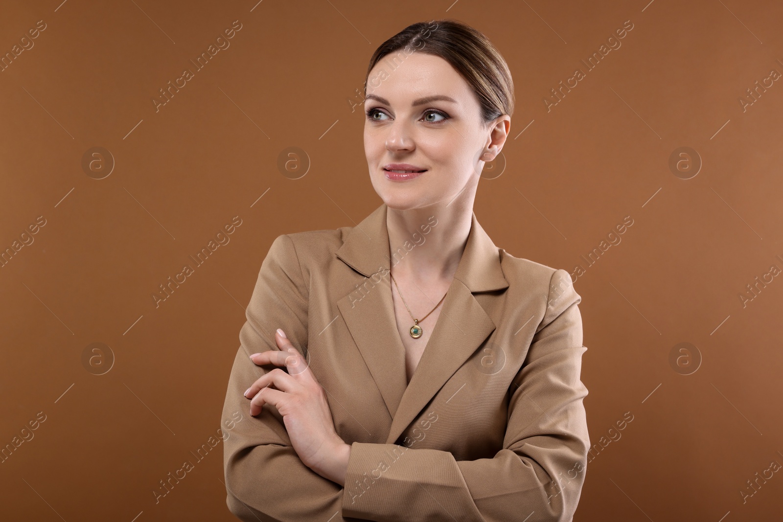 Photo of Beautiful woman with elegant necklace on brown background