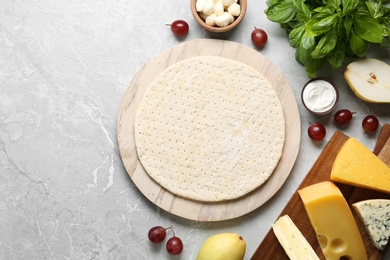 Photo of Flat lay composition with pizza crust and fresh ingredients on marble table