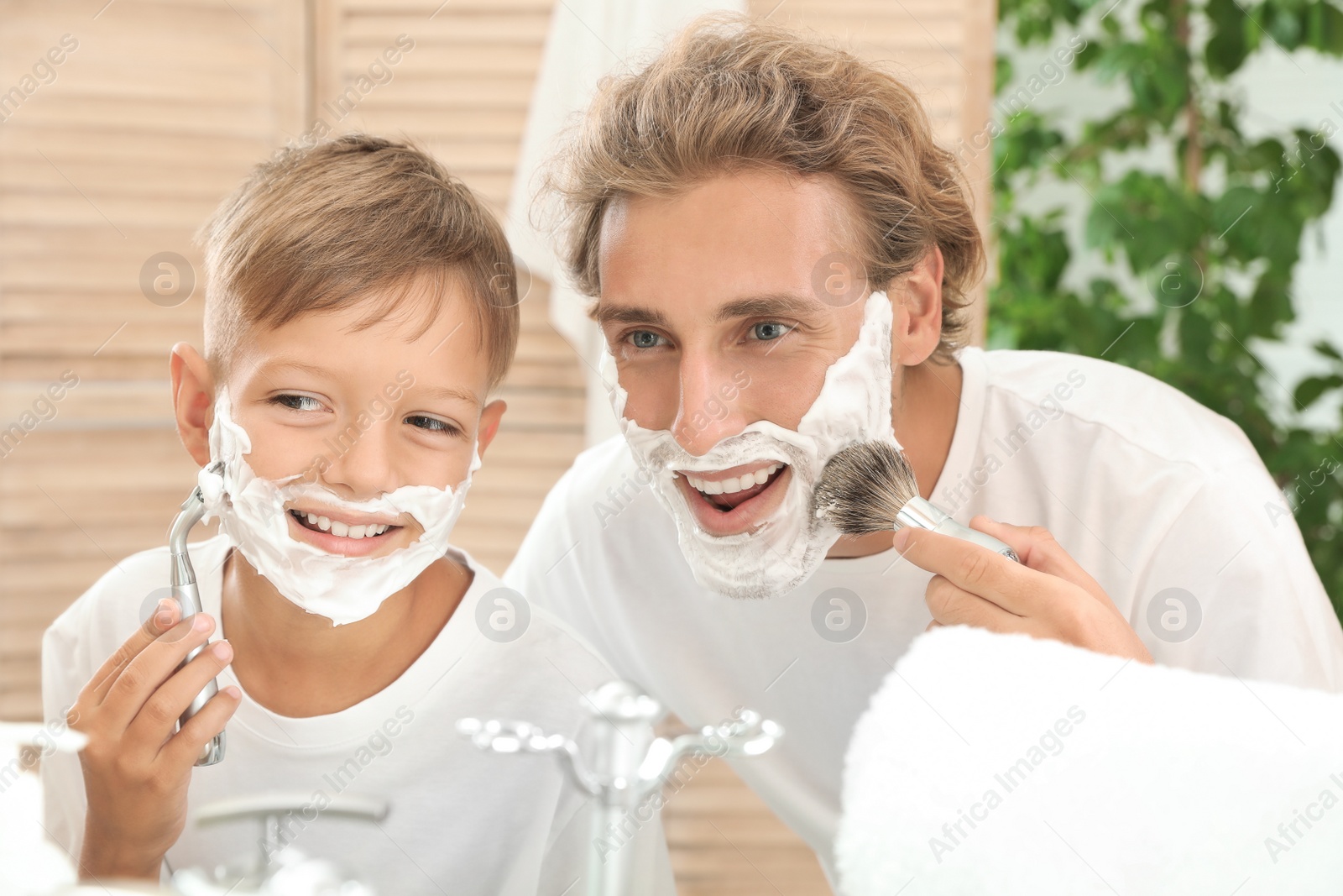 Photo of Father and son shaving together in bathroom
