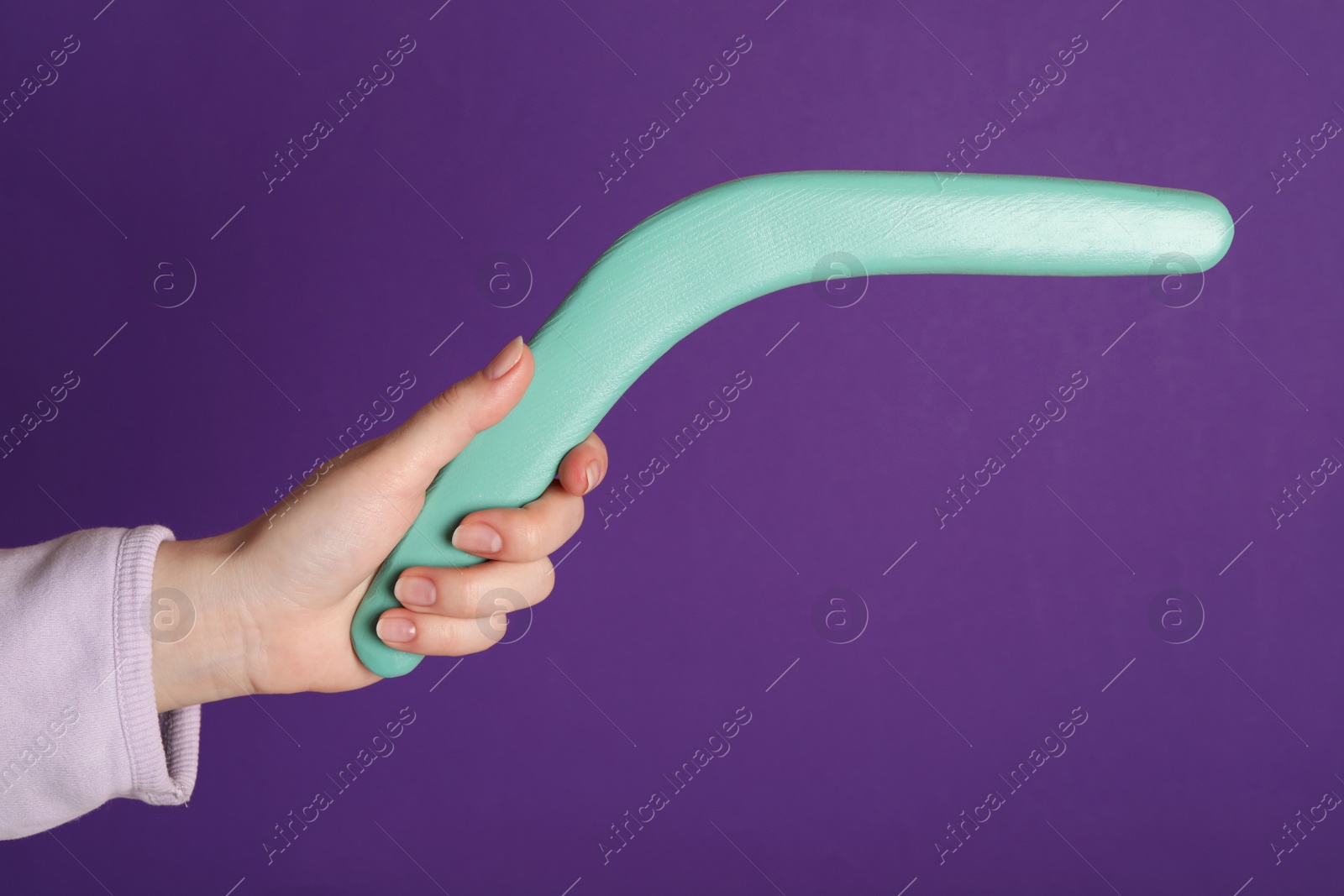 Photo of Woman holding boomerang on purple background, closeup