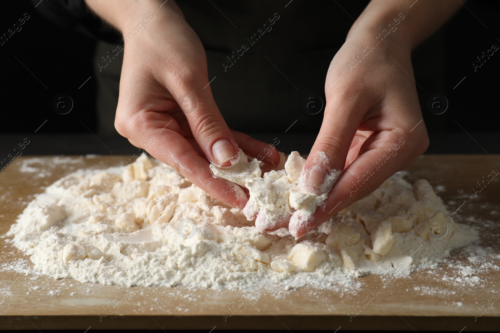 Photo of Woman making shortcrust pastry at table, closeup