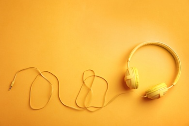 Stylish headphones on color background, top view. Space for text