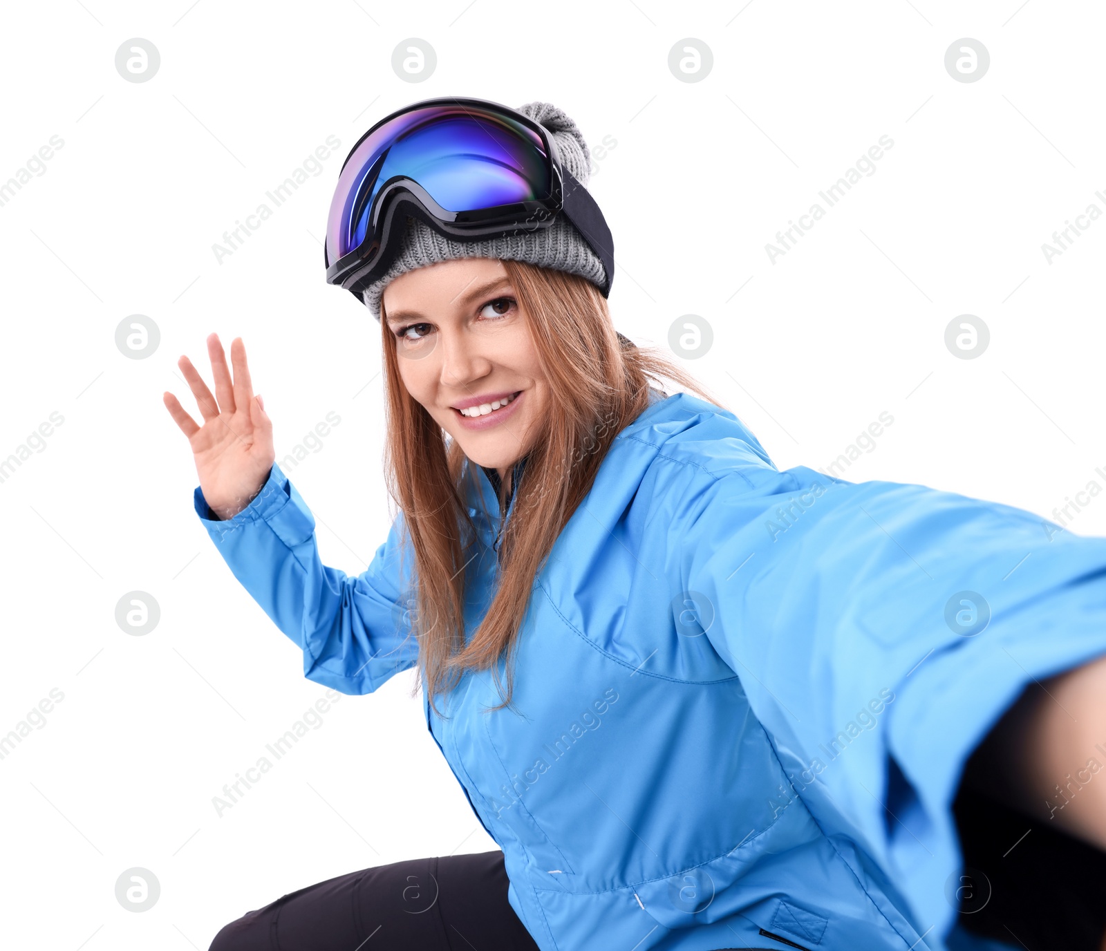 Photo of Beautiful woman in ski goggles taking selfie on white background