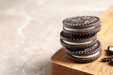 Board with chocolate cookies on table. Space for text