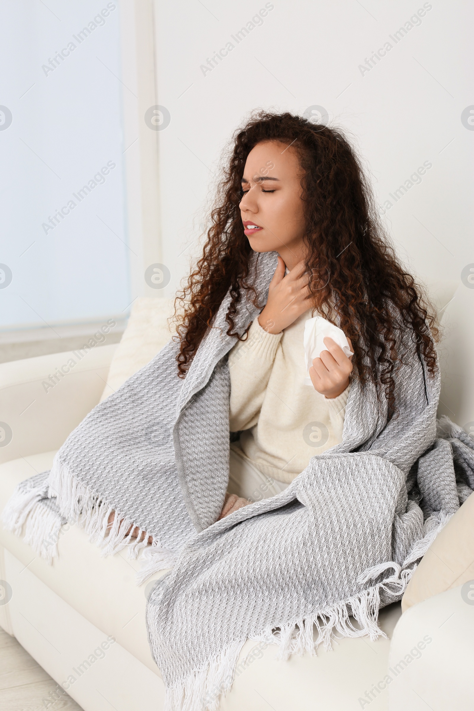 Photo of Sick African American woman with tissue at home