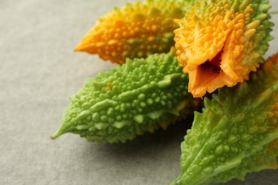 Photo of Fresh bitter melons on grey cloth, closeup