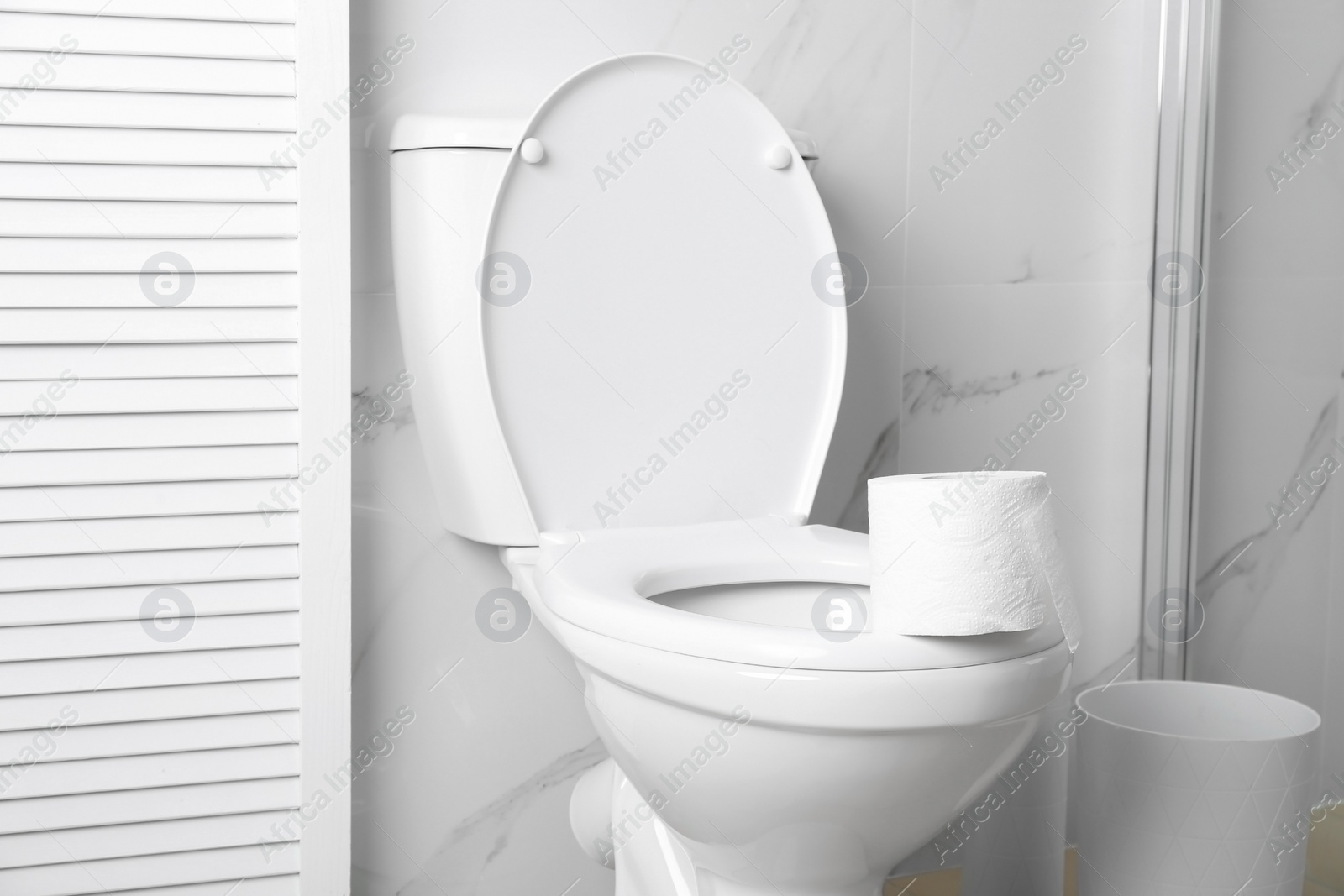 Photo of New paper roll on toilet bowl in bathroom