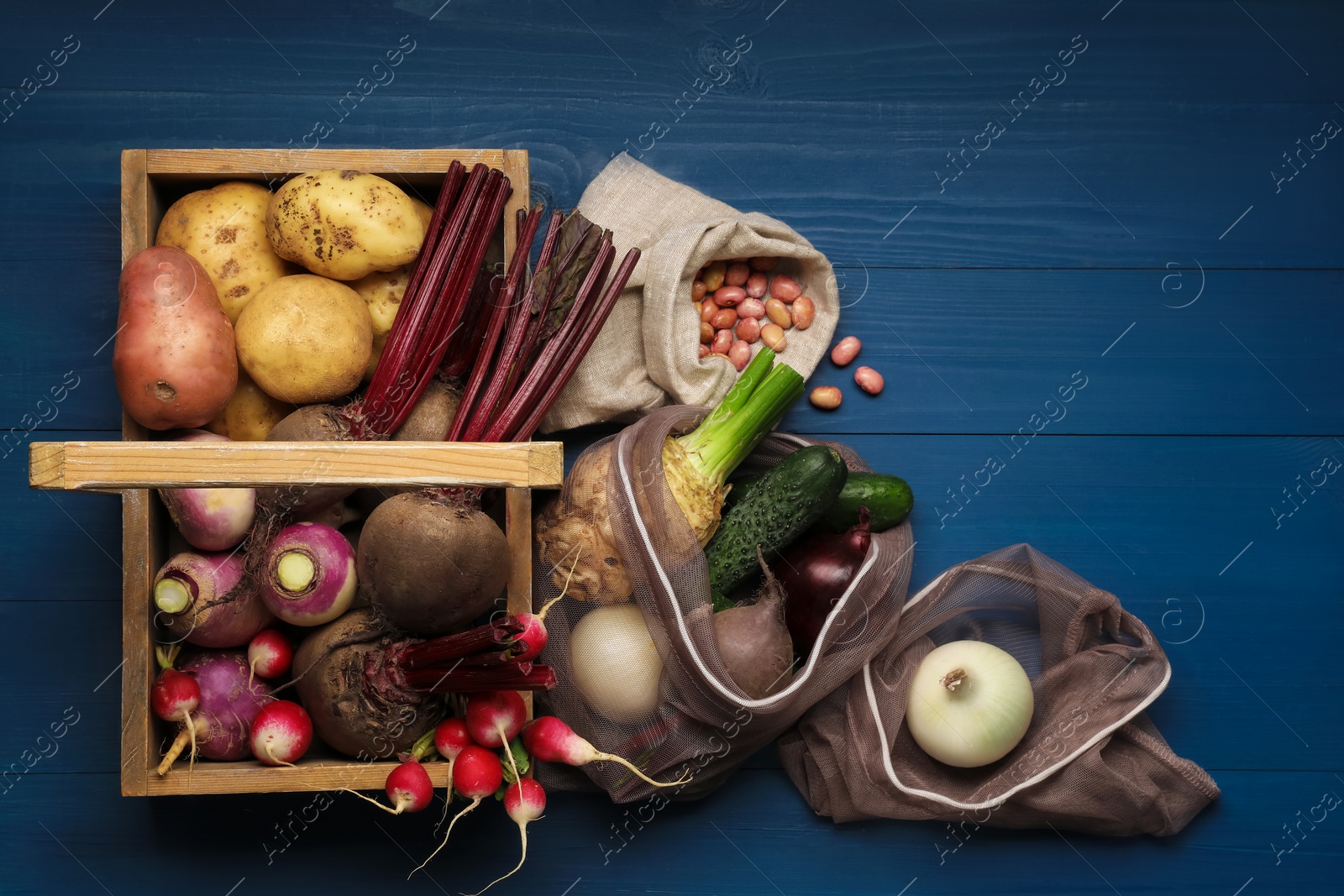 Photo of Different fresh ripe vegetables on blue wooden table, flat lay. Space for text