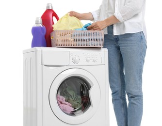 Photo of Woman with laundry basket and detergents near washing machine on white background, closeup