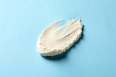 Smear of tasty cream cheese on color background