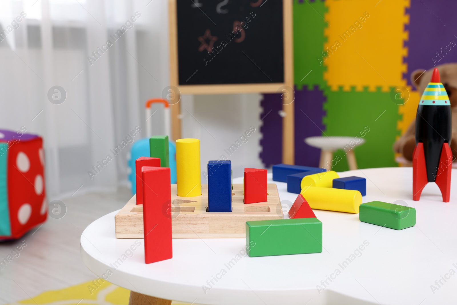 Photo of Different toys on white table in kindergarten