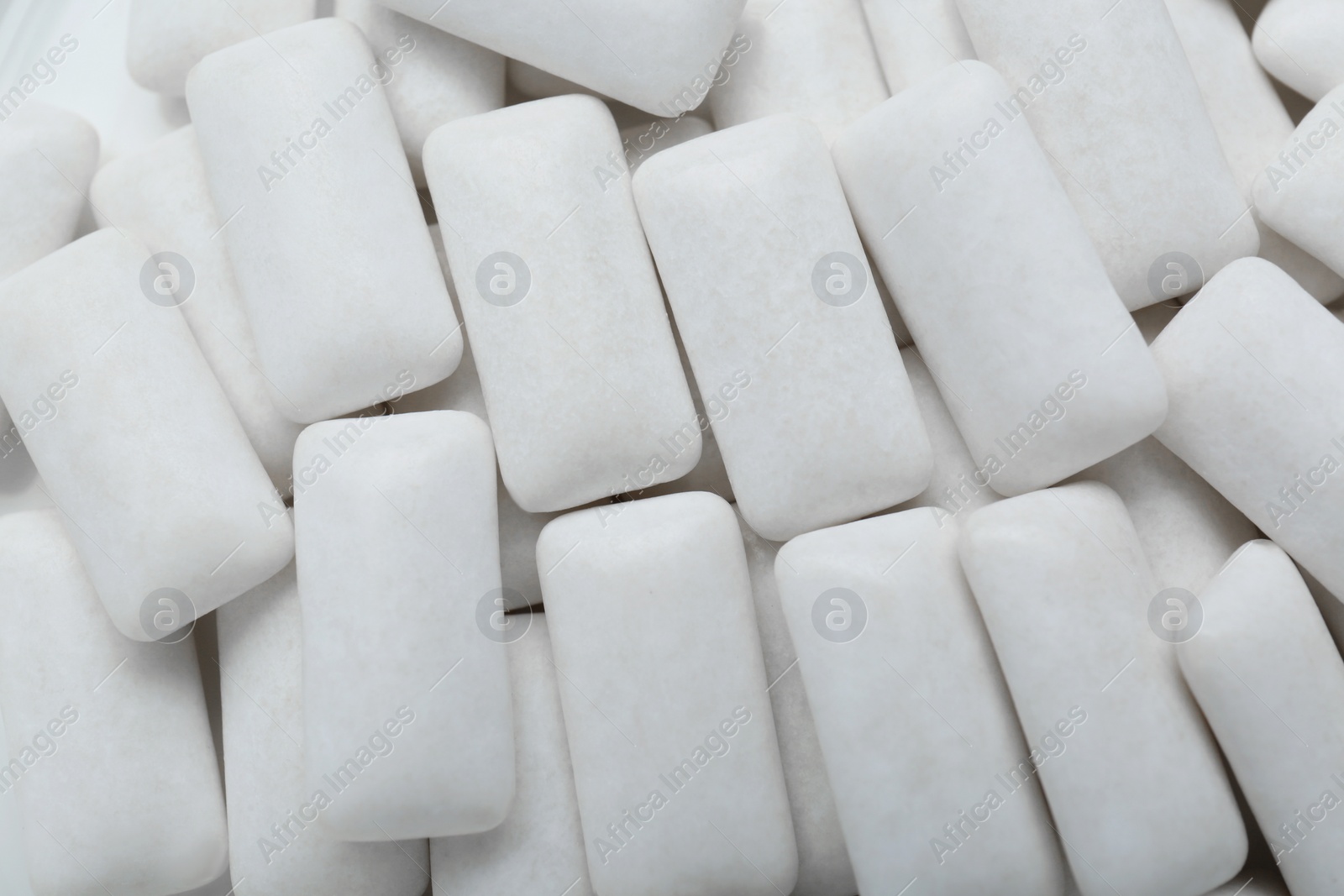 Photo of Tasty white chewing gums as background, top view