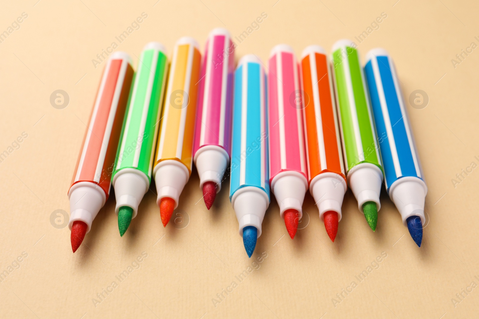 Photo of Many bright colorful markers on beige background
