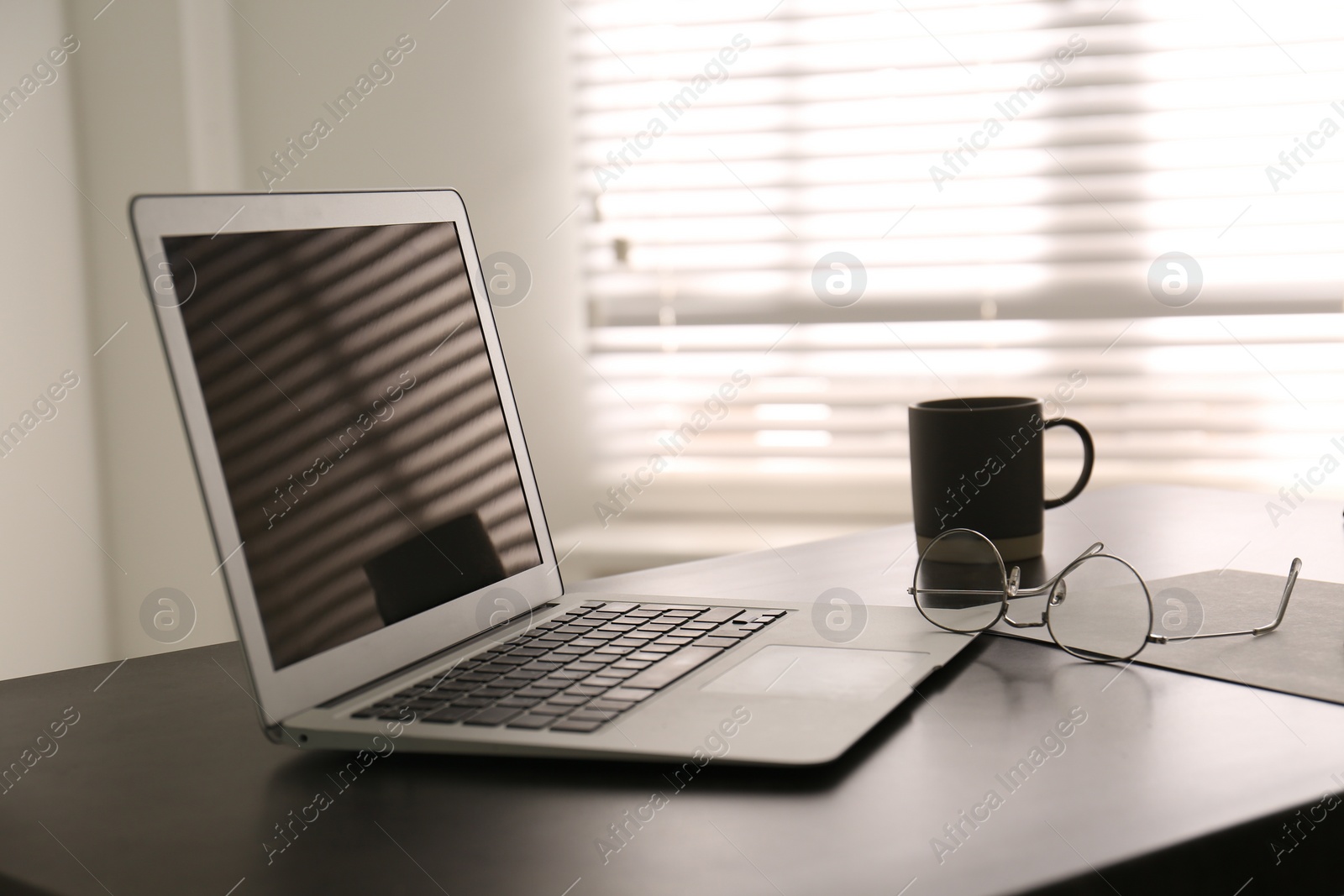 Photo of Modern laptop on office table. Stylish workplace