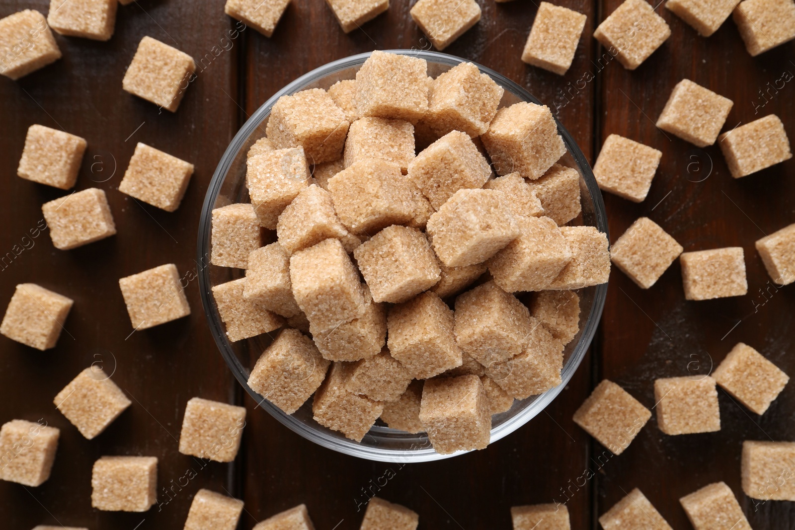 Photo of Brown sugar cubes on wooden table, flat lay