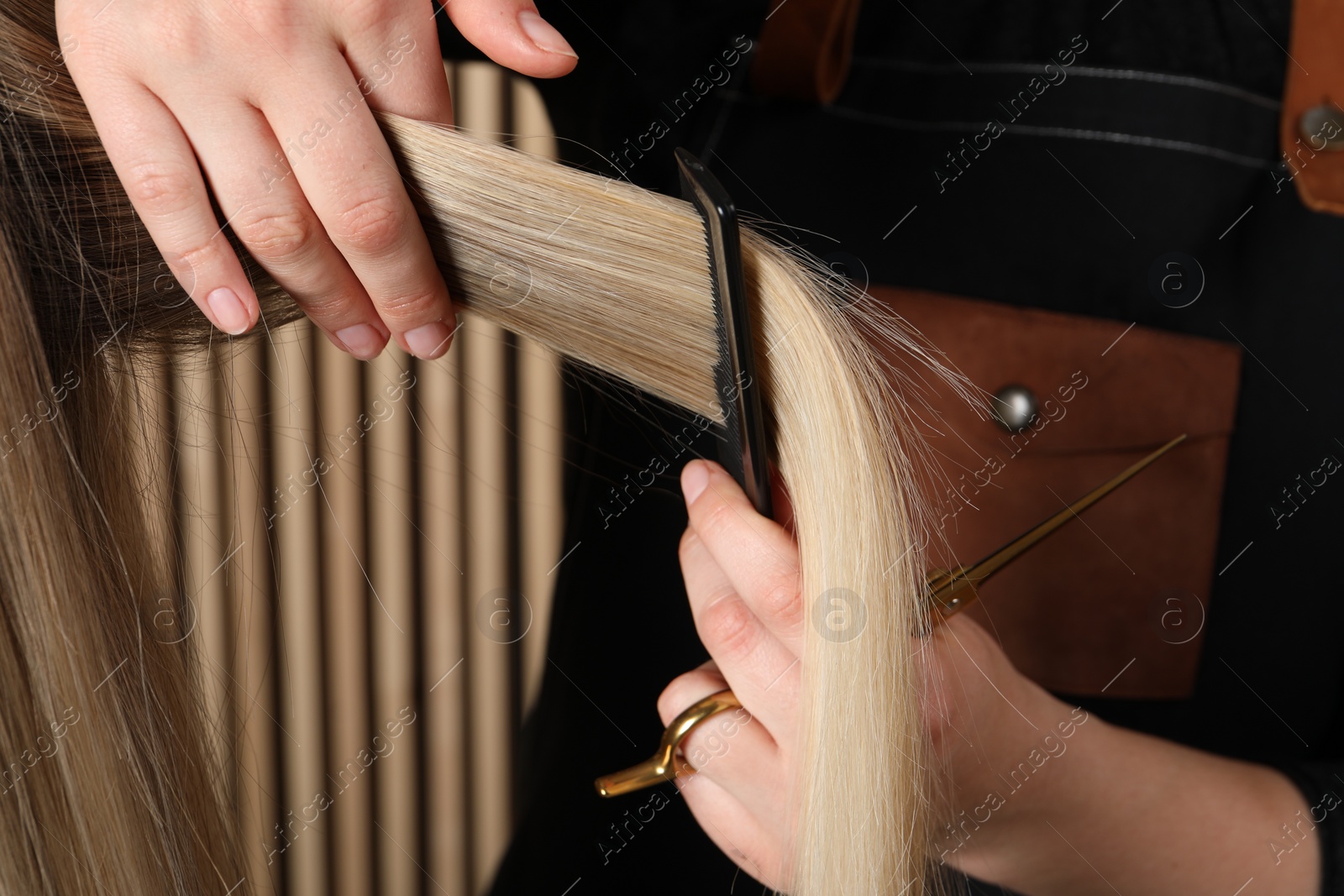 Photo of Hairdresser combing client's hair in salon, closeup