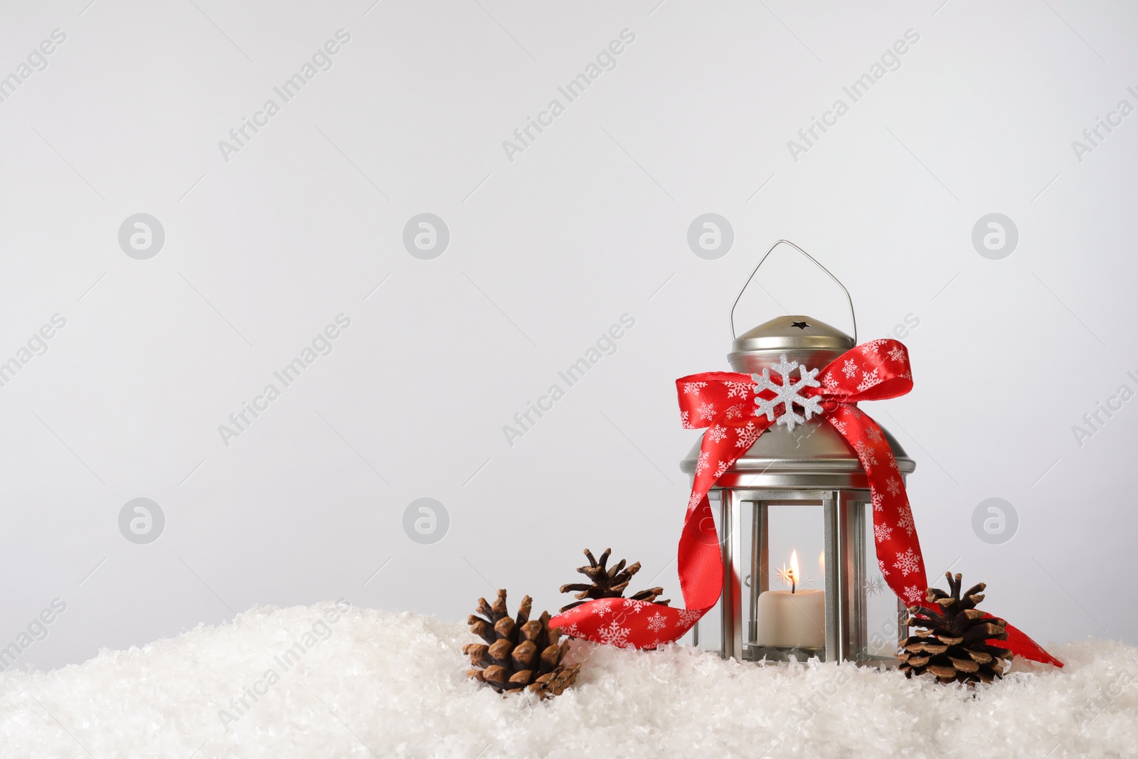 Photo of Beautiful composition with vintage Christmas lantern and festive decorations on snow against white background. Space for text