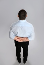 Photo of Man in formal clothes on grey background, back view