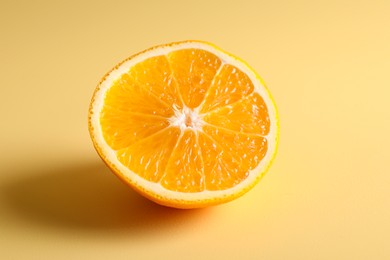 Photo of Half of juicy orange on beige background