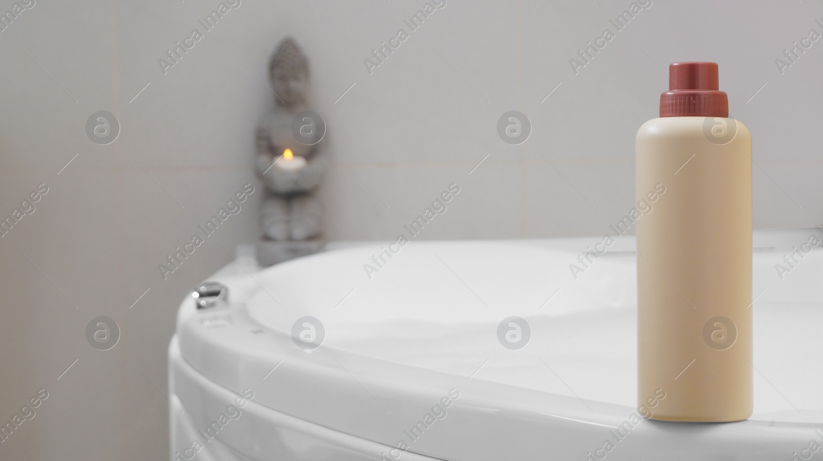 Beige bottle of bubble bath on tub indoors, space for text Photo of Beige bottle of bubble bath on tub indoors, space for text