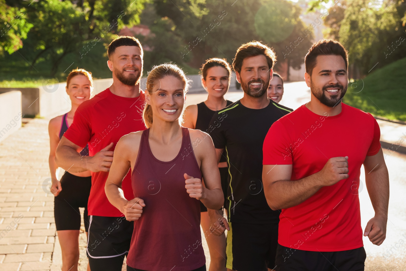 Photo of Group of people running outdoors on sunny day