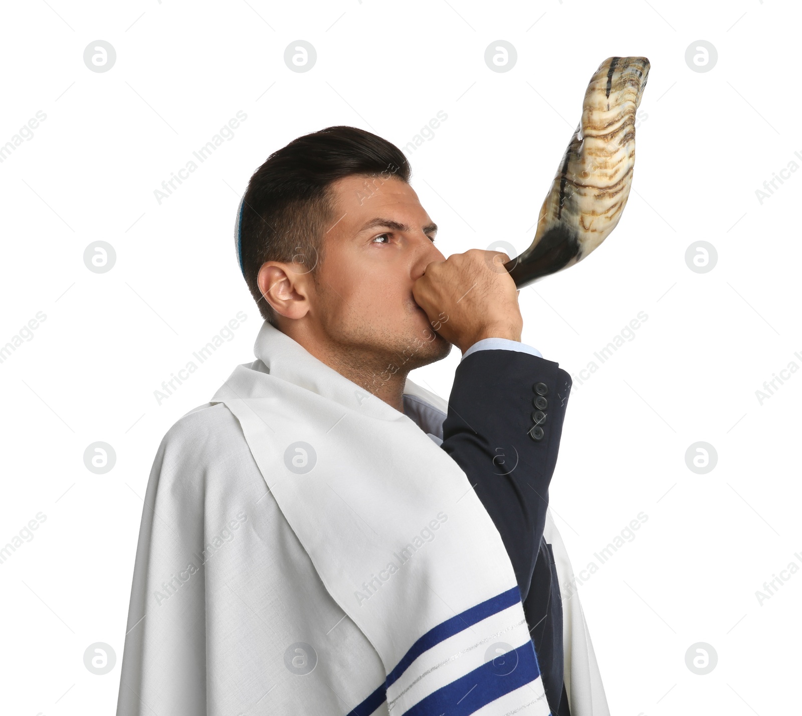 Photo of Jewish man with kippah and tallit blowing shofar on white background. Rosh Hashanah celebration