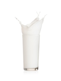 Milk splashing out of glass on white background