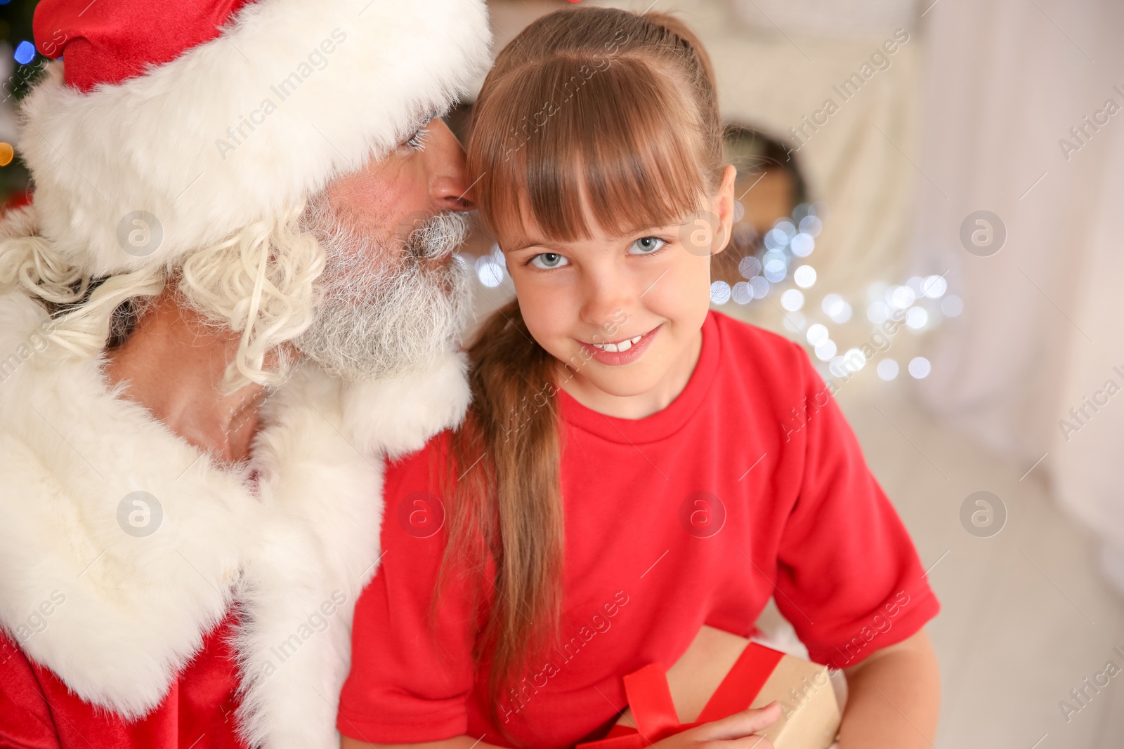 Photo of Little child with Santa Claus and Christmas gift at home