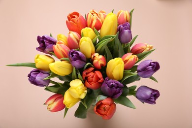 Photo of Bouquet of beautiful tulips on beige background, top view