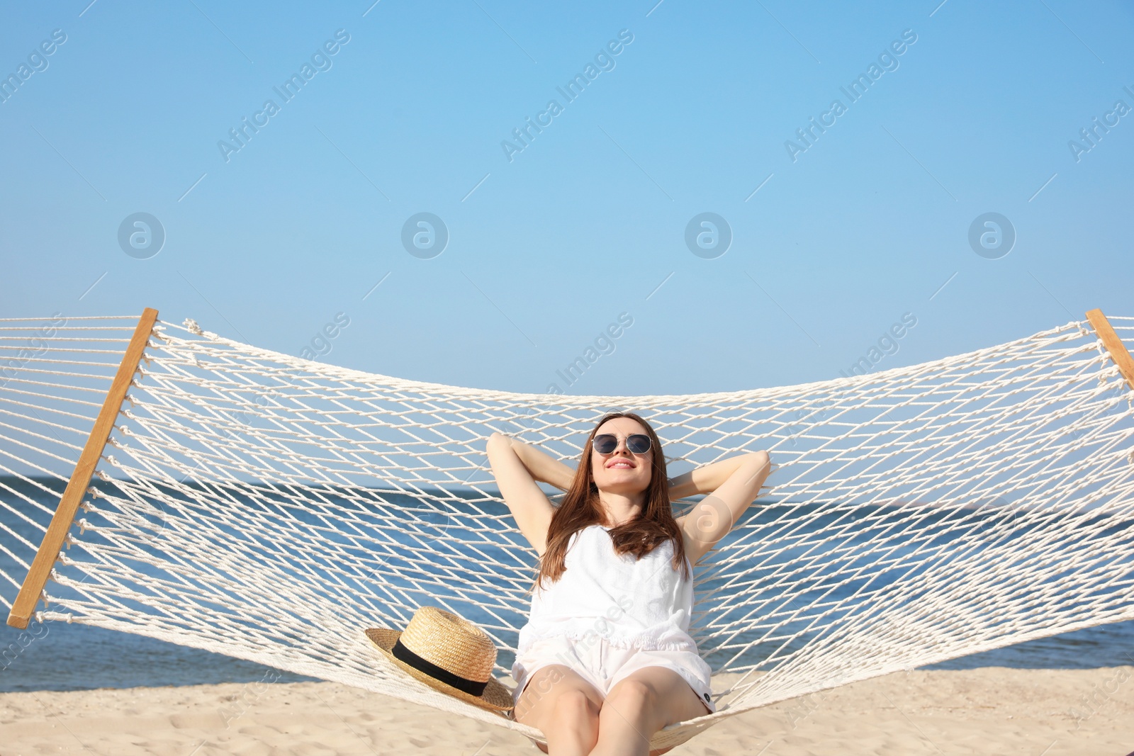 Photo of Young woman relaxing in hammock on beach